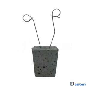 Concrete spacer with tie wire for reinforcement alignment in formwork applications.