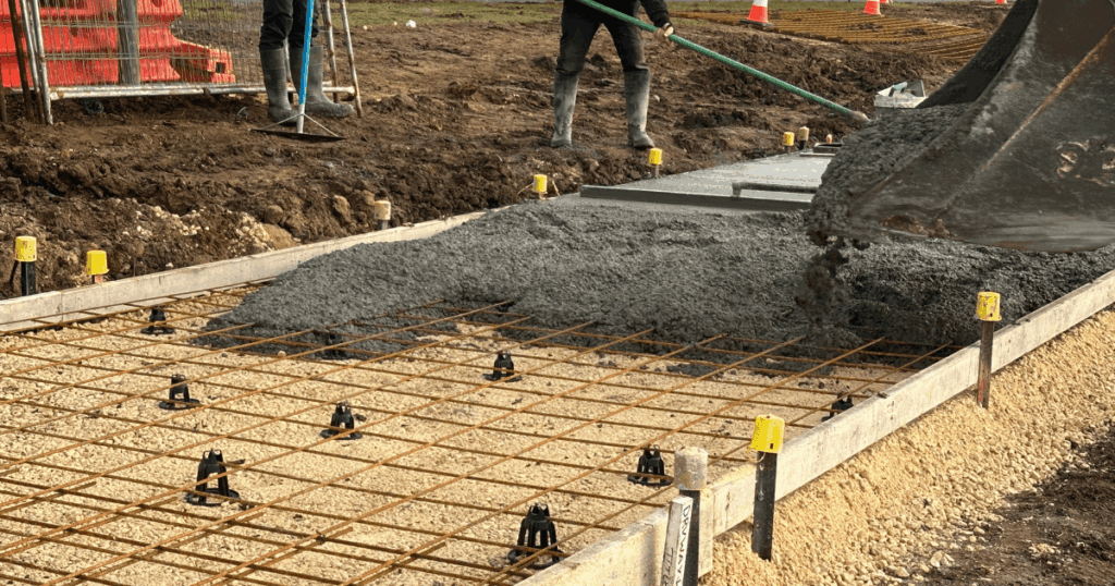 SOG bar chairs supporting steel reinforcement mesh during slab-on-ground concrete pouring.