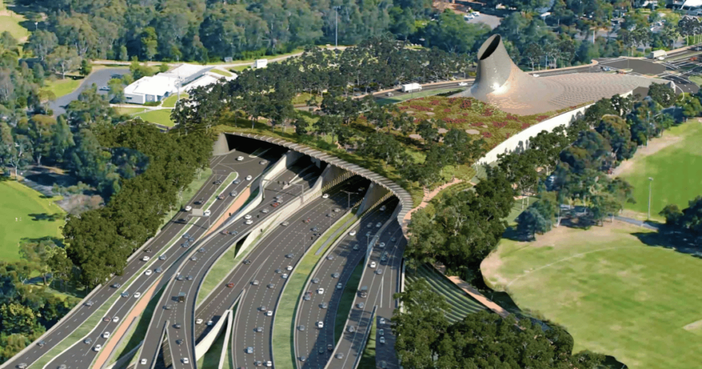 Aerial view of the North East Link tunnel entrance, featuring a modern roadway design surrounded by green landscapes in Melbourne