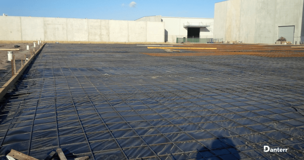 Builders film installed beneath rebar for moisture control in concrete curing
