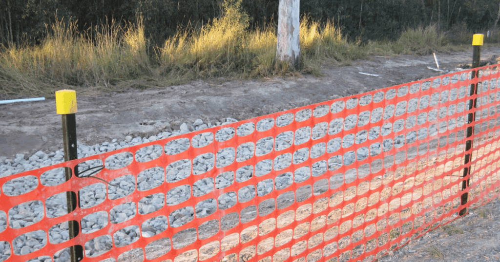 Orange barrier mesh with yellow safety caps used for site safety compliance in Australia