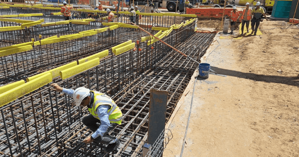 Construction workers on-site with yellow Nevosafe rebar caps installed for site safety compliance in Australia