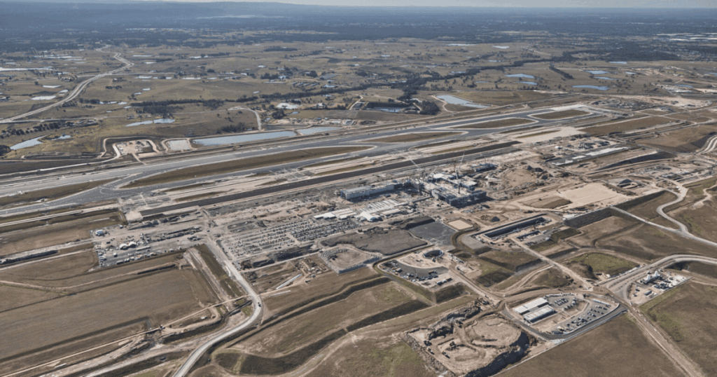 Aerial view of Western Sydney Airport terminal construction site with runways, infrastructure works, and surrounding landscape.