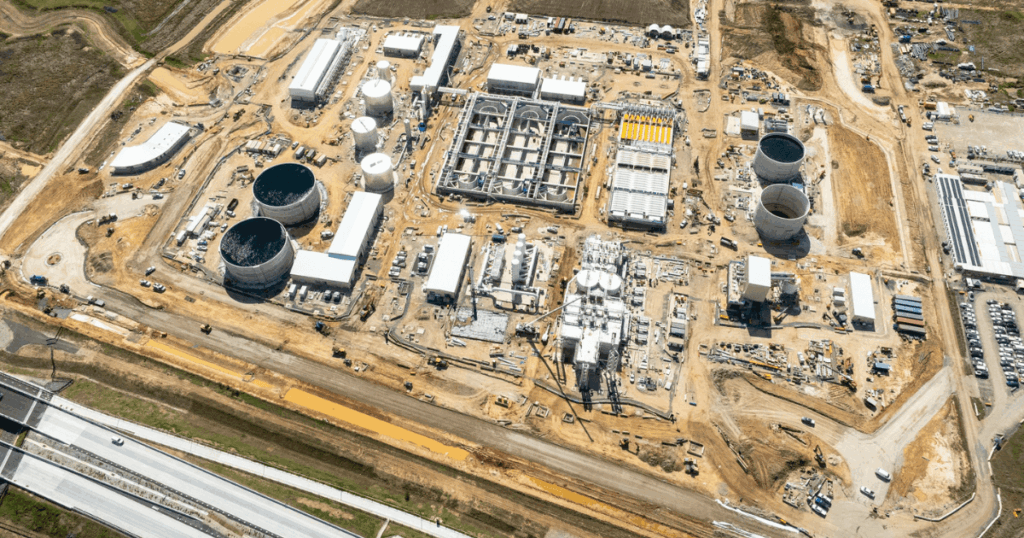 Aerial view of construction progress at the Upper South Creek Advanced Water Recycling Centre in Kemps Creek NSW, showing large tanks, treatment structures, and active work zones.
