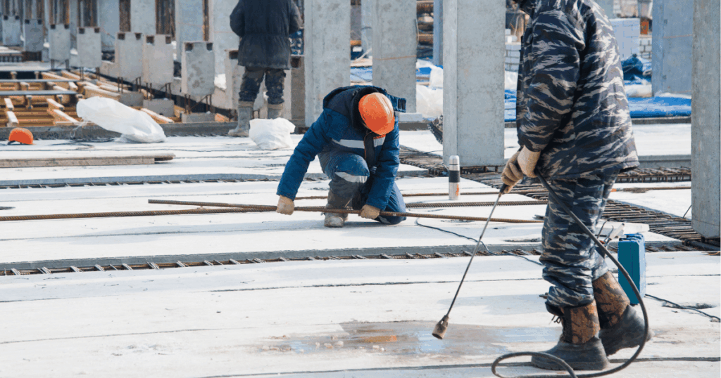 Workers installing Ecotherm insulation during concrete casting to protect fresh concrete and support effective concrete curing in cold weather.